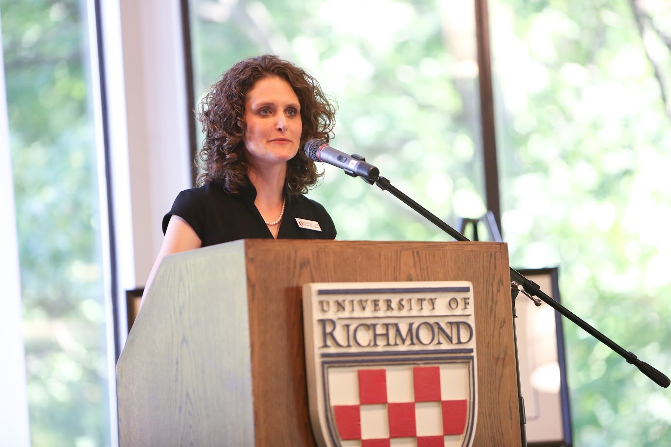 Bryn Taylor speaking at a lectern displaying the University of Richmond shield.